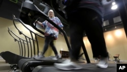 Gym members use as treadmill to warm up for a morning exercise class at Downsize Fitness, in Addison, Texas, Jan. 3, 2013. 