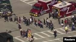 Students are evacuated from Marjory Stoneman Douglas High School during a shooting in Parkland, Florida, Feb. 14, 2018, in this still image from video.