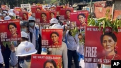 Para demonstran memegang foto dari pemimpin Myanmar yang digulingkan Aung San Suu Kyi dalam aksi unjuk rasa anti kudeta militer di Mandalay, Myanmar, pada 5 Maret, 2021. (Foto: AP, File)