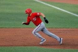 Washington Nationals' Trea Turner tries to steal second base against the Baltimore Orioles during an exhibition baseball game, July 20, 2020, in Baltimore. Turner was caught stealing by catcher Bryan Holaday.