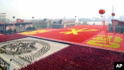 지난 2007년 4월 평양 김일성 광장에서 건군 75주년 기념 열병식에 동원된 주민들이 빨간색 바탕에 노란색으로 '영광'이라는 글자와 노동당 마크를 새겼다. 최근 VOA가 입수한 김일성 광장 위성사진에도 대규모 인파가 열병식을 준비하는 움직임이 포착됐다.