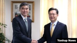 미국측 수석대표인 성김 국무부 동아태 부차관보 겸 대북정책 특별대표(왼쪽)와 한국측 6자회담 수석대표인 황준국 한반도평화교섭본부장(오른쪽)이 10월 27일 서울 외교부에서 만나 악수하고 있다. (자료사진)