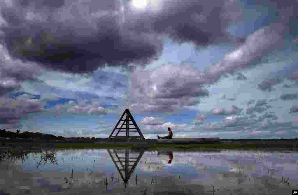 Brian Ellis meditates on a log under clearing skies near an exercise structure at Back Cove, in Portland, Maine.