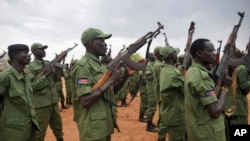 FILE - South Sudanese rebel soldiers raise their weapons at a military camp in the capital, Juba, South Sudan, April 7, 2016.