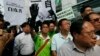 Protesters raise a mock "white paper", left, released by Beijing State Council on Tuesday saying it holds ultimate control over the former British colony, outside the Chinese liaison office in Hong Kong, June 11, 2014. 