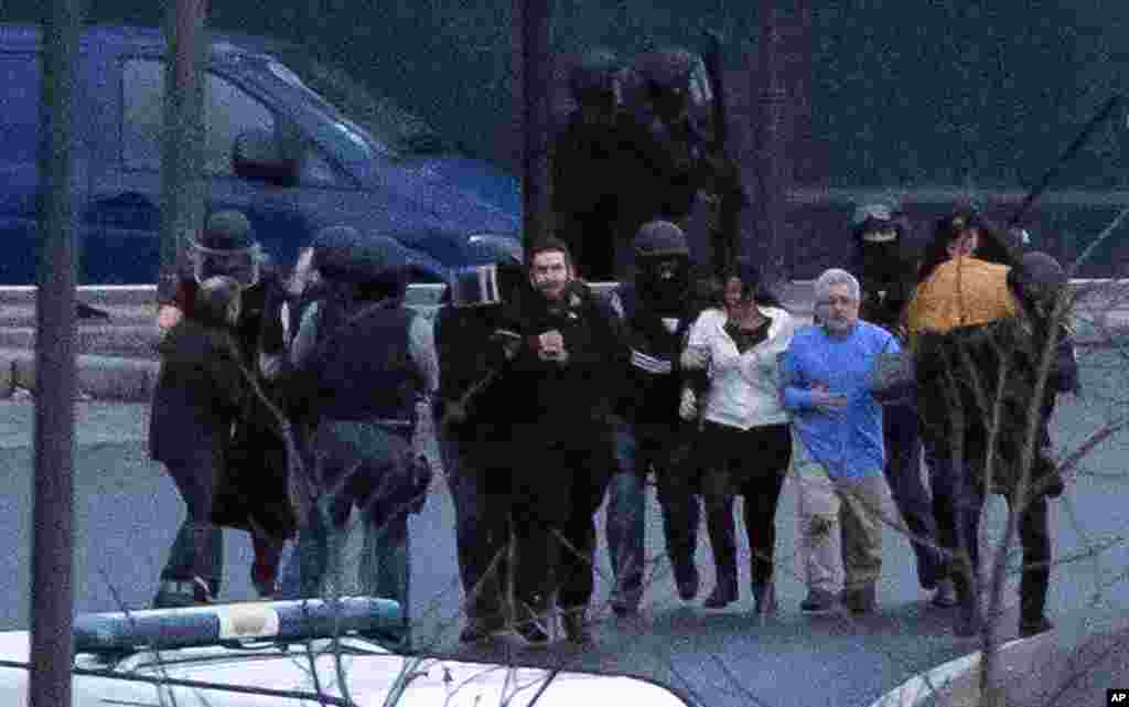 Security officers escort released hostages after they stormed a kosher market to end a hostage situation, Paris, Jan. 9, 2015.