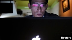 FILE - Vietnamese Internet activist Nguyen Lan Thang chats on Facebook at a cafe in Hanoi Nov. 27, 2013.