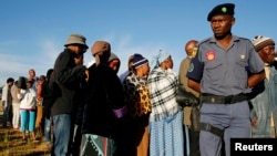 FILE - A police officer looks on at a voting station during the Lesotho national election in Magkhoakhoeng village outside the capital Maseru , Feb. 28, 2015. 