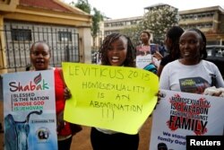Anti-gay rights protesters hold placards after a ruling by Kenya's high court to upheld a law banning gay sex, outside the Milimani high Court in Nairobi, Kenya, May 24, 2019.
