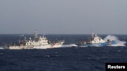 在距離越南海岸約210公里(130英里)的南中國海，越南海上警衛隊的一艘船(右)靠近一艘中國海警船。（2014年5月14日）