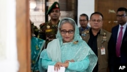 Mantan Perdana Menteri Bangladesh Sheikh Hasina tampak memeriksa jam tangannya saat menunggu giliran untuk menggunakan hak pilihnya di salah satu tempat pemungutan suara di Dhaka, Bangladesh, pada 7 Januari 2024. (Foto: AP/Altaf Qadri)