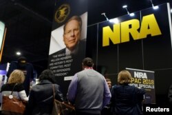 FILE - People sign up at the booth for the National Rifle Association at the Conservative Political Action Conference at National Harbor, Md., Feb. 23, 2018.