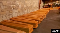 Deretan peti jenazah korban meninggal akibat virus corona di sebuah kapel di Bergamo, Lombardy, Italia, sebelum dikirim ke kremasi. (Foto: ANSA/AFP)