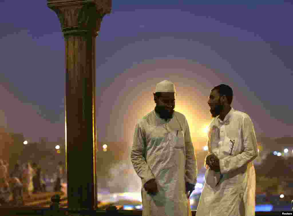Para Muslim bersantai di luar ruangan setelah berbuka puasa di hari pertama bulan suci Ramadan di India, di Masjid Akbar, di wilayah kota tua di Delhi, India, 30 Juni 2014.