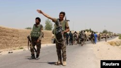 An Afghan National Army (ANA) soldier gestures as they arrive in Nad Ali district of Helmand province, southern Afghanistan, Aug. 10, 2016. 