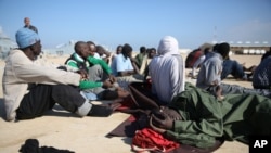 FILE - African migrants rest after their rescue by the Libyan Coast Guard west of Tripoli, Dec. 21, 2015.