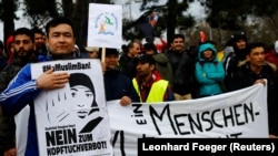 Para pengunjuk rasa memegang spanduk saat demonstrasi menentang rasisme dan kebijakan suaka Eropa di Wina, Austria, 18 Maret 2017. Spanduk bertuliskan "Tidak untuk larangan jilbab". (Foto: REUTERS/Leonhard Foeger)