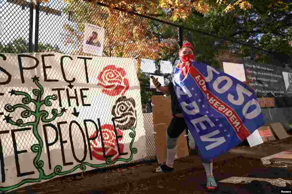 Jordan Johnson poses with a Biden flag outside the White House, after a presidential election victory was called for former Vice President Joe Biden, in Washington, Nov. 8, 2020.