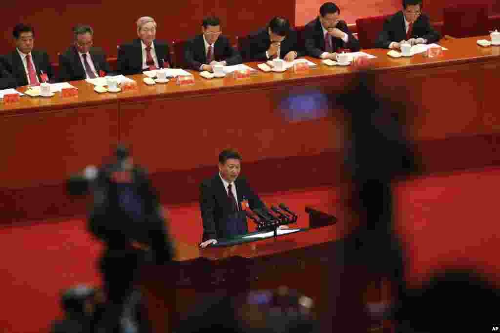 中共总书记习近平在北京人大会堂召开的中共19大开幕式上发表讲话(2017年10月18日)。他身后坐着贾庆林、吴邦国、朱镕基、张高丽、刘云山、张德江、胡锦涛等人。朱镕基的满头白发和别人的黑色染发形成对比。在习近平讲话前对主席台上其他人鞠躬时,朱镕基和大家一起鼓掌。而网上视频显示,在习近平做完报告后,在全场热烈掌声中,朱镕基没有鼓掌,至少没有像别人那样抬起手来明显地鼓掌。