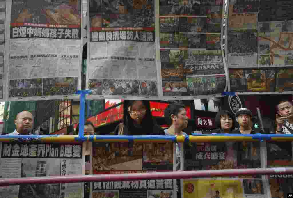 香港游客浏览示威者和警察之间冲突的最新报道