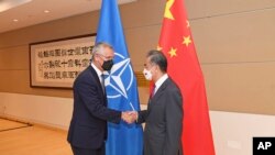 中國外長王毅（右）與北約秘書長斯托爾滕貝格。