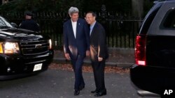 Secretary of State John Kerry, left, walks with Chinese State Councilor Yang Jiechi outside Kerry's home on Beacon Hill in Boston, Friday, Oct. 17, 2014.