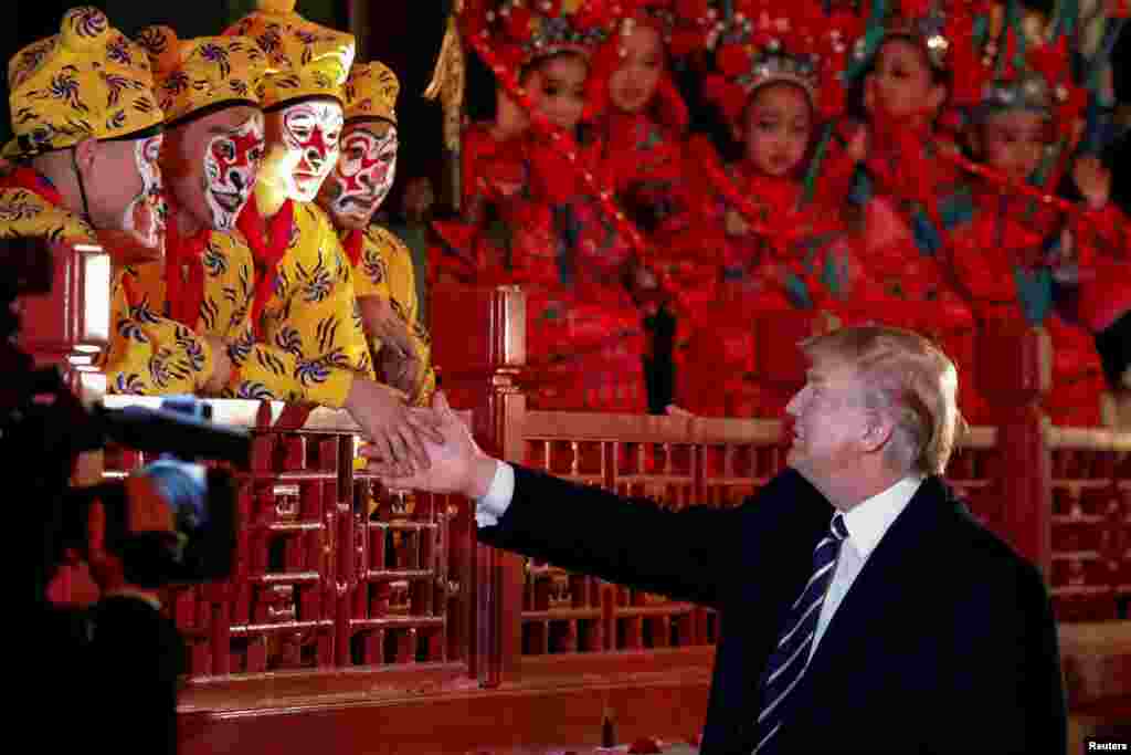 President Donald Trump shakes hands with opera performers at the Forbidden City in Beijing, China, Nov. 8, 2017.