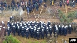 Hasil tangkapan layar dari video yang dirilis of Kementerian Pertahanan Polandia menunjukkan para migran yang terlibat bentrokan dengan petugas keamanan di wilayah perbatasan Polandia-Belarusia di Kuznica pada 8 November 2021. (Foto: Handout/Polish Defence Ministry/AFP)