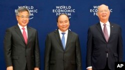 Vietnamese Prime Minister Nguyen Xuan Phuc, center, Chinese Vice Premier Hu Chunhua, left, and Klaus Schwab, executive chair of the World Economic Forum, pose prior to the World Economic Forum on ASEAN Wednesday, Sept. 12, 2018 .
