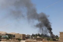 FILE - A plume of smoke rises amid ongoing fighting between Afghan security forces and Taliban insurgeents in the western city of Qala-e-Naw, the capital of Afghanistan's Badghis province, July 7, 2021.