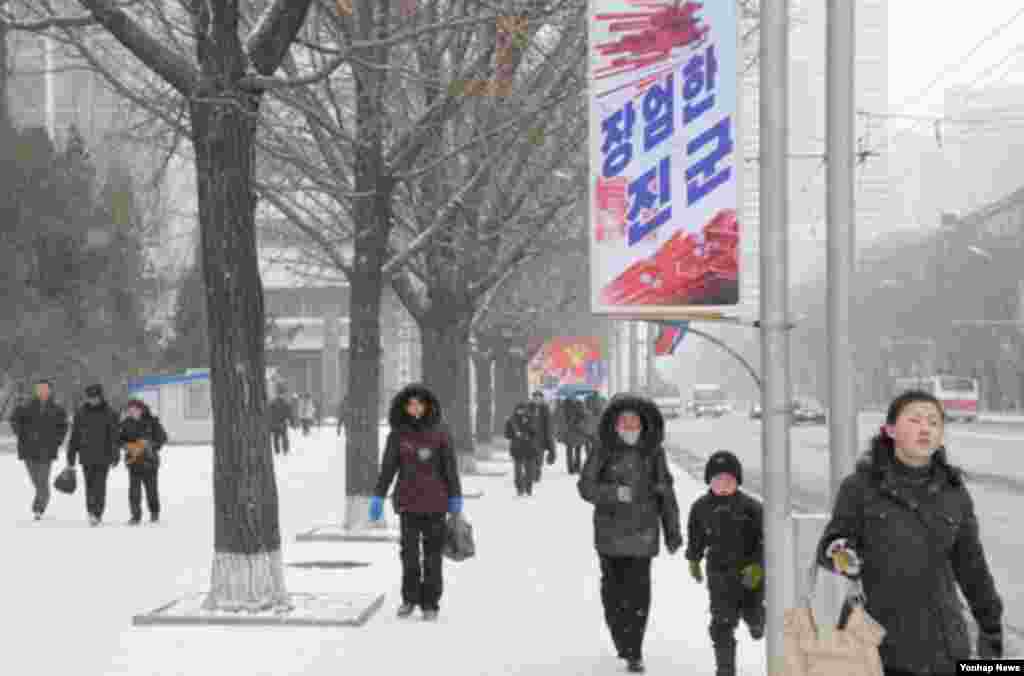 북한이 핵실험을 강행한 12일 오후 북한 시민들이 '장엄한 진군'이라고 쓰인 현수막이 내걸린 평양 거리를 걷고 있다.
