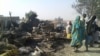 People return to the site after a bombing attack by a Nigerian military jet of an internally displaced persons camp in Rann, Nigeria Jan. 17, 2017. Officials say the bombing was an accident and is under investigation.