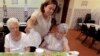 Cristina Couto, supervisor at Ironbound Senior Center, pours water for elderly bingo players, Newark, New Jersey, June 21, 2012.