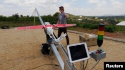 Seorang insinyur dari Zipline mempersiapkan drone untuk uji penerbangan dari pangkalan operasi di Muhanda, selatan ibukota Rwanda, Kigali (foto: REUTERS/James Akena)