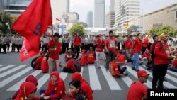 Para pekerja beristirahat di sela pawai Hari Buruh (May Day) di Jakarta, Indonesia, 1 Mei 2018. (Foto: REUTERS/Beawiharta)