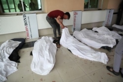A young man try to identify dead bodies at a hospital after a bomb explosion near a school west of Kabul, Afghanistan, May 8, 2021.