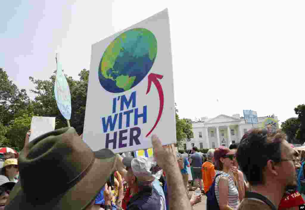 Participants walk along Pennsylvania Ave., in front of the White House in Washington, during a demonstration and march, April 29, 2017. Thousands of people gather across the country to march in protest of President Donald Trump's environmental policies, which have included rolling back restrictions on mining, oil drilling and greenhouse gas emissions at coal-fired power plants.