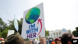 Para peserta berjalan di sepanjang Pennsylvania Ave, di depan Gedung Putih di Washington selama unjuk rasa dan pawai hari Sabtu, 29 April 2017 (foto: AP Photo/Pablo Martinez Monsivais) 