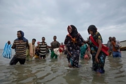 FILE - Ethiopian migrants disembark from a boat onto the shores of Yemen on July 26, 2019. Over the course of Yemen's civil war, African migrants have endured unspeakable cruelties, often perilously close to front lines.