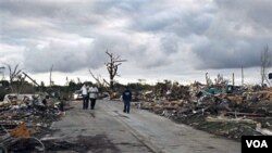 Warga berjalan di sekitar rumah-rumah yang hancur akibat badai hebat dan angin topan tornado di Birmingham , Alabama, Kamis (28/4).