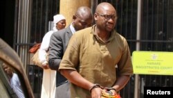 Pastor Evan Mawarire is escorted by detectives as he arrives at court to face charges of attempting to subvert the government, in Harare, Zimbabwe, Sept. 26, 2017. 
