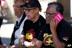 Beberapa perempuan masyarakat adat sedang menunggu di tempat pemungutan suara di Redfern di tengah pelaksanaan referendum hak-hak masyarakat adat, di Sydney, Australia, Sabtu, 14 Oktober 2023. (Foto: Rick Rycroft/AP Photo)
