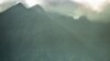 FILE - An afternoon shower rolls in over the volcanic mountains of Virunga National Park, home to a famous gorilla reserve, Sept. 23, 1997. The Democratic Republic of Congo is planning to sell land blocks that extend into the park to use for oil and gas exploration.