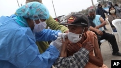
Crisologo Enriquez yang berusia delapan puluh lima tahun saat menerima vaksin di Lima, Peru, Jumat, 26 Juni 2020. (Foto: AP)