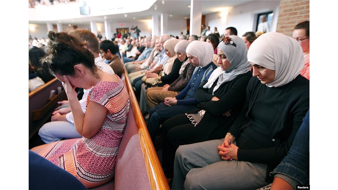 FILE - People from different faiths pray during a vigil in Chattanooga, Tennessee, July 17, 2015. “Three quarters of Americans, about 77 percent of the population, still identify with a religious group,” said Alan Cooperman, director of religion research at the Washington-based Pew Research Center.