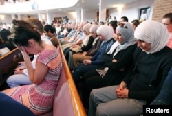 FILE - People from different faiths pray during a vigil in Chattanooga, Tennessee, July 17, 2015. “Three quarters of Americans, about 77 percent of the population, still identify with a religious group,” said Alan Cooperman, director of religion research at the Washington-based Pew Research Center.