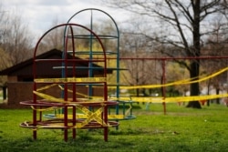 Playground equipment is wrapped in crime scene tape to prevent its use as part of the effort to slow the spread of the coronavirus March 31, 2020, in St. Louis, MIssouri.