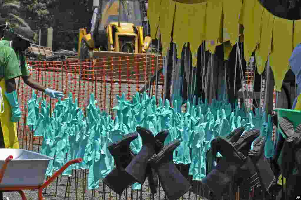 Ebola health care workers' protective gear, including gloves and rubber boots, dries in the sun after being washed at a clinic in Monrovia, Liberia, Sept. 8, 2014. 
