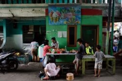 Anak-anak berkumpul di warung jajanan di lingkungan Muara Baru, di tengah pandemi COVID-19 di Jakarta, 14 Juli 2021. (REUTERS/Willy Kurniawan)