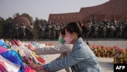 지난 15일 북한 김일성 주석의 108번째 생일을 맞아 마스크를 쓴 주민들이 만수대언덕 김일성 동상에 꽃을 놓고 있다.